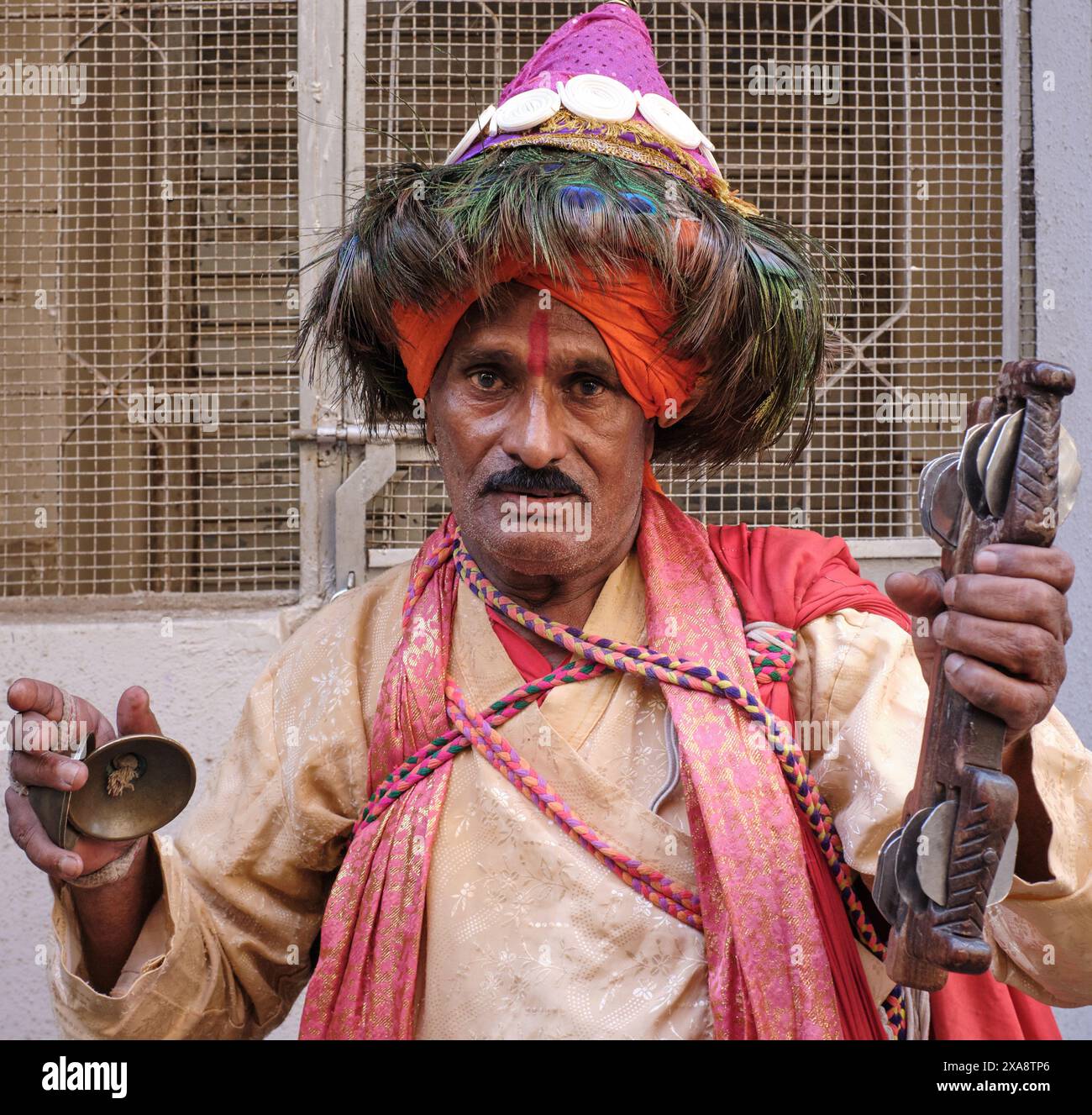 Ein Vasudew, ein Anbeter des hinduistischen Gottes Krishna im indischen Bundesstaat Maharashtra, der Lieder singt, um Krishna zu loben und Almosen sammelt; Mumbai, Indien Stockfoto