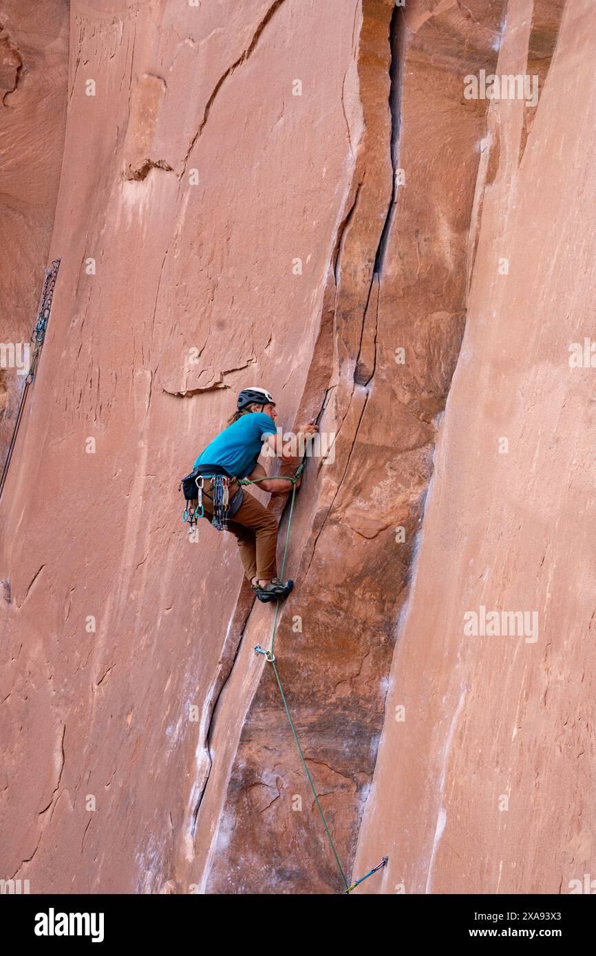 Ein Lead Climber Crack klettert an der Wall Street in der Nähe von Moab, Utah. Stockfoto