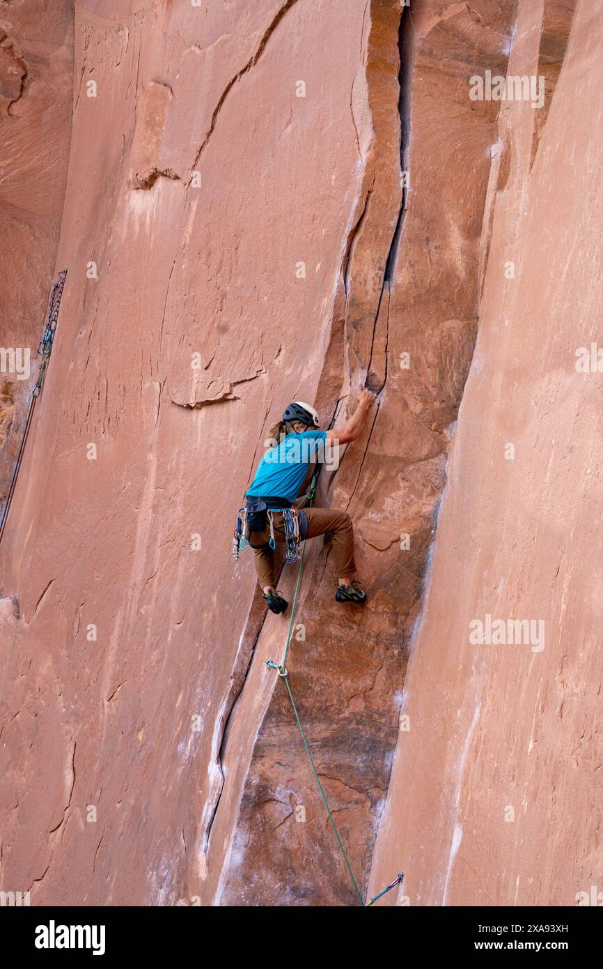 Ein Lead Climber Crack klettert an der Wall Street in der Nähe von Moab, Utah. Stockfoto
