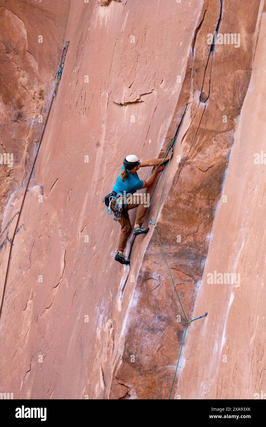 Ein Lead Climber Crack klettert an der Wall Street in der Nähe von Moab, Utah. Stockfoto