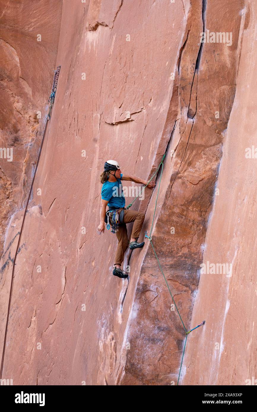 Ein Lead Climber Crack klettert an der Wall Street in der Nähe von Moab, Utah. Stockfoto