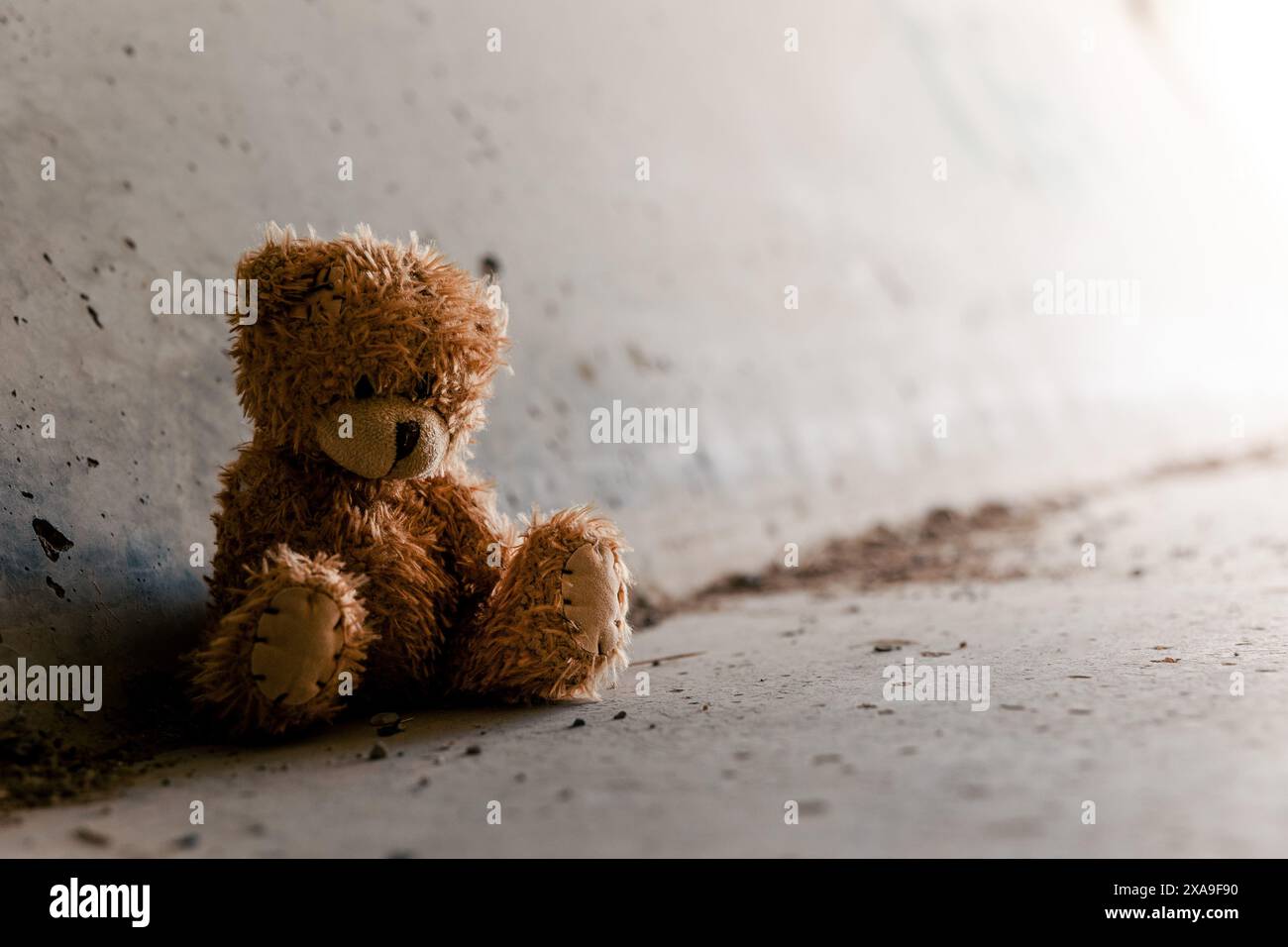 Obdachloser einsamer armer Teddybär, der in einem dunklen Tunnel unter der Brücke sitzt. Obdachlosigkeit, Armut, Depression, Drogenabhängigkeit Konzeptbild Stockfoto