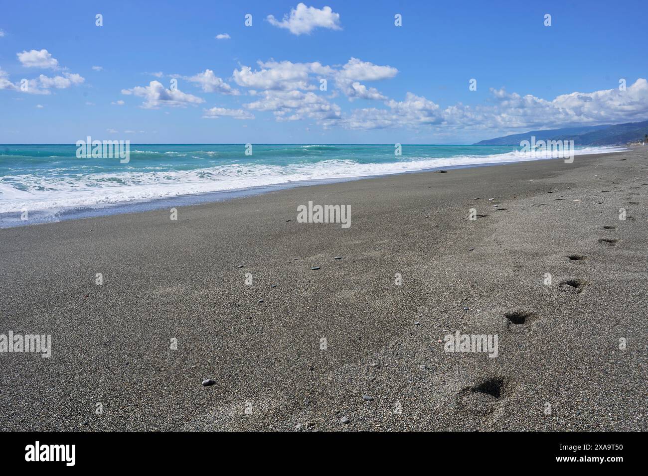 Einige Fußspuren am Sandstrand mit Wellen Stockfoto