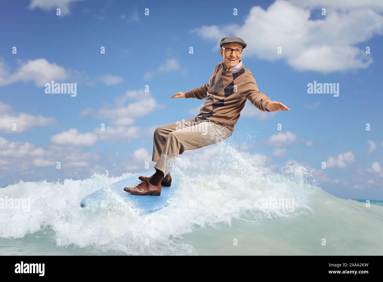 Ein älterer Mann, der auf einer Welle im Meer surft Stockfoto