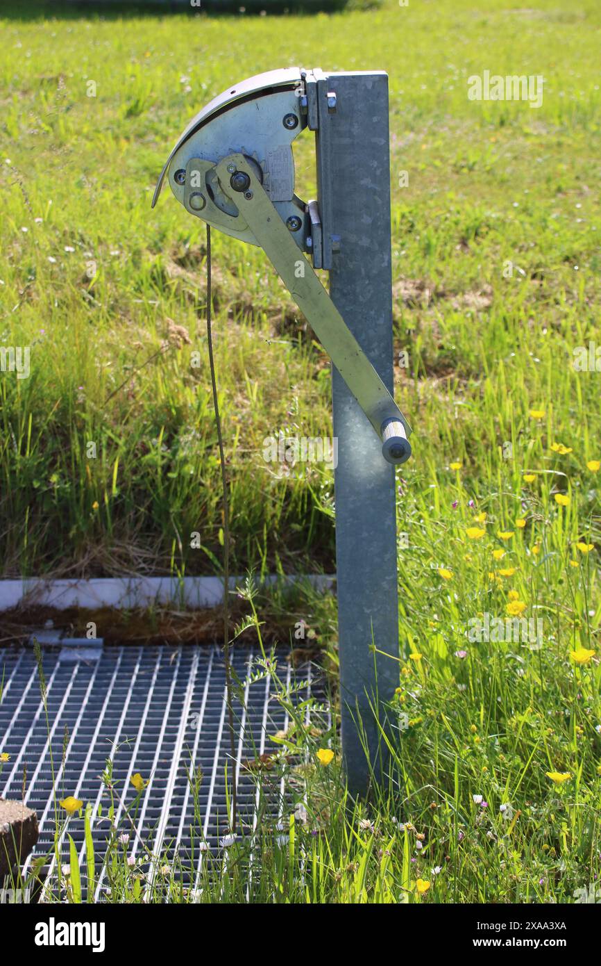 Die Seilwinde aus Edelstahl steht auf einem Gitter auf einem Regenbecken Stockfoto