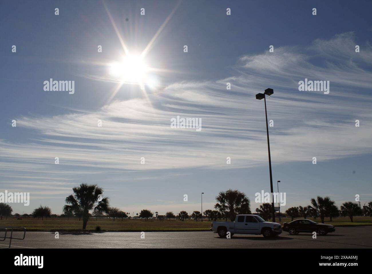 Zwei Autos parkten auf einem Parkplatz, die Sonne scheint hell am Himmel Stockfoto