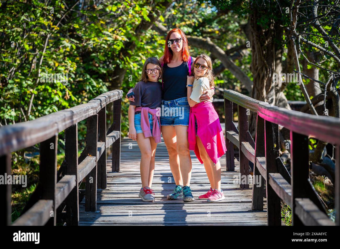 Familienwanderung auf Holzbrücken der Krka-Wasserfälle. Mutter und Töchter spazieren über den hölzernen Brückenweg auf dem Fluss Krka und Wasserfällen in Kroatien. Stockfoto