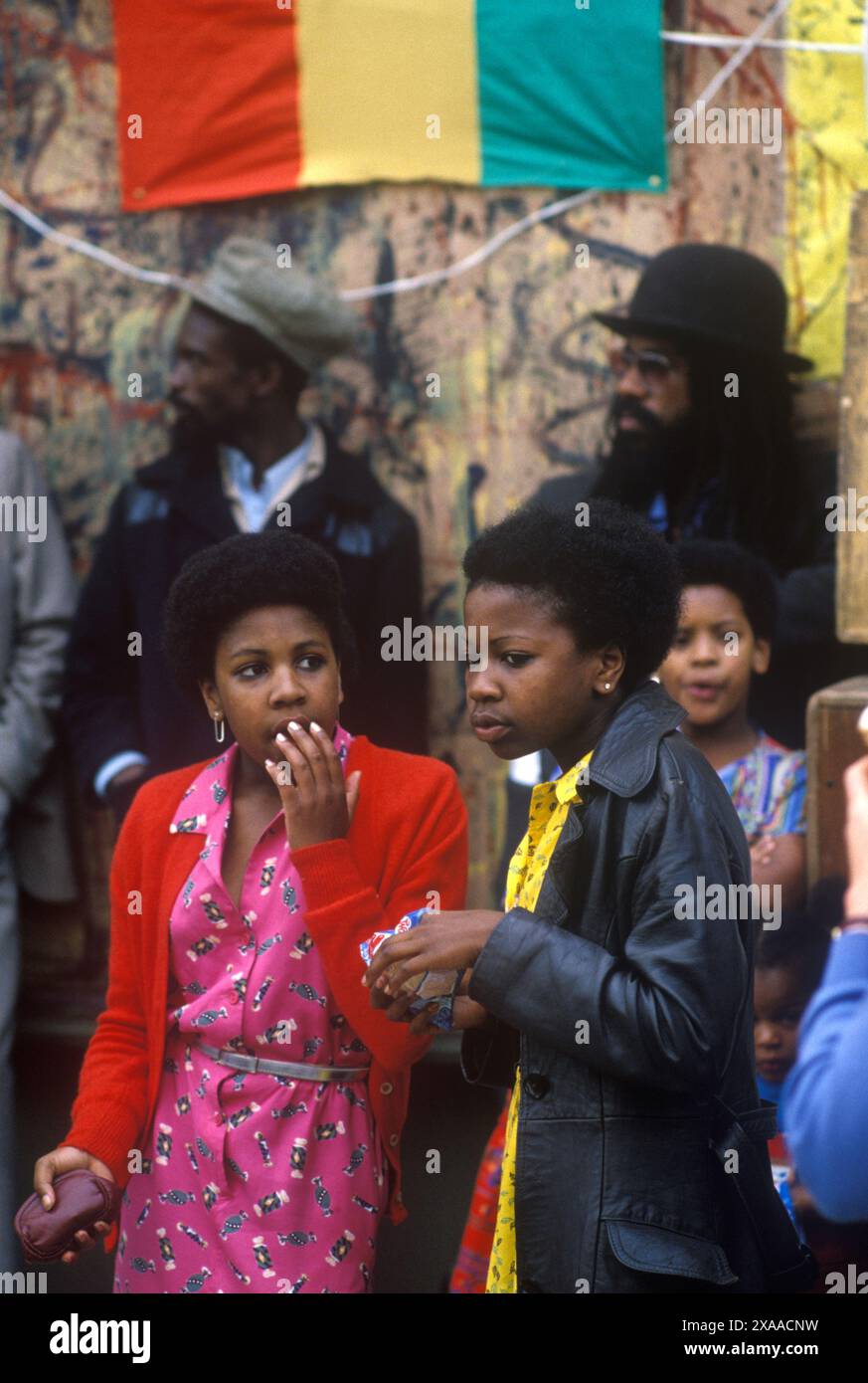 1970er Jahre Großbritannien zwei schwarze britische Teenager-Mädchen, die in modischen Kleidern der damaligen Zeit herumstehen. Notting Hill Karneval August Bankfeiertag Montag. London, England, 27. August 1979. HOMER SYKES Stockfoto