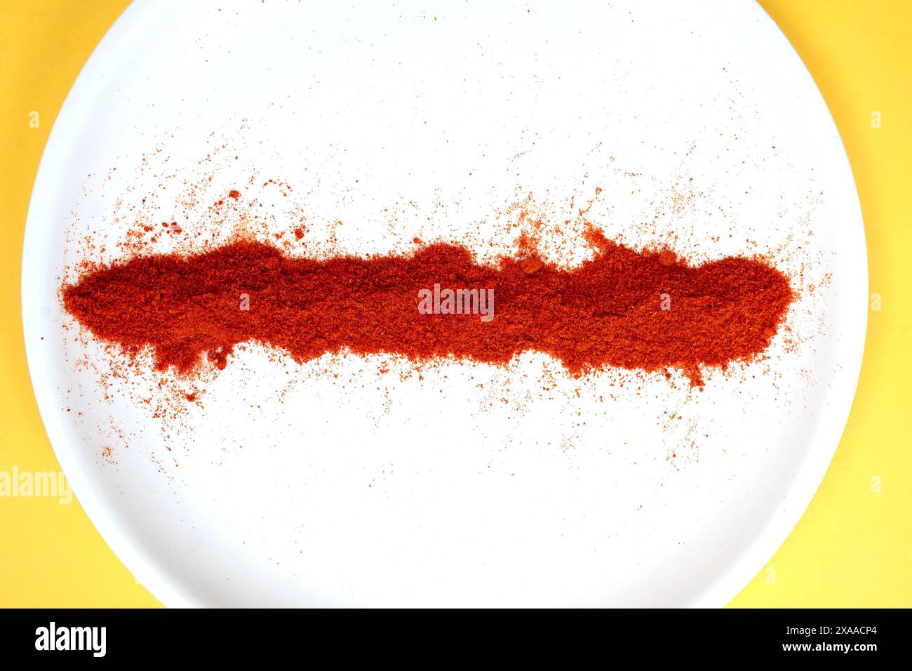 Eine Streuung von rotem Chili-Pfefferpulver auf weißem Hintergrund. Stockfoto