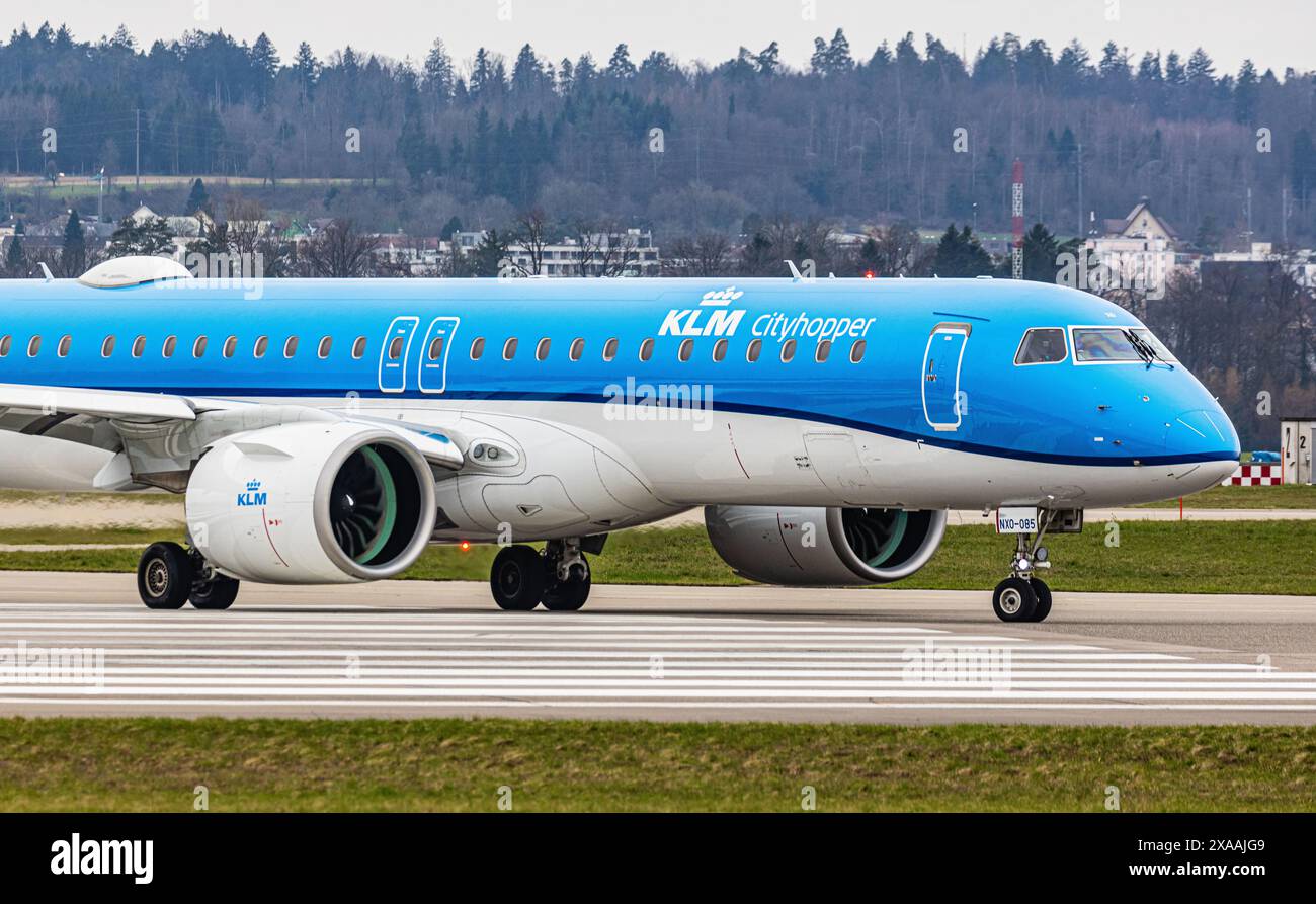 Ein Embraer 195-E2 vom KLM Cityhopper fährt mit dem Taxi auf die Start- und Landebahn am Flughafen Zürich, wo sie auf die Freigabe wartet. Registrierung PH-NXO. (Zu Stockfoto