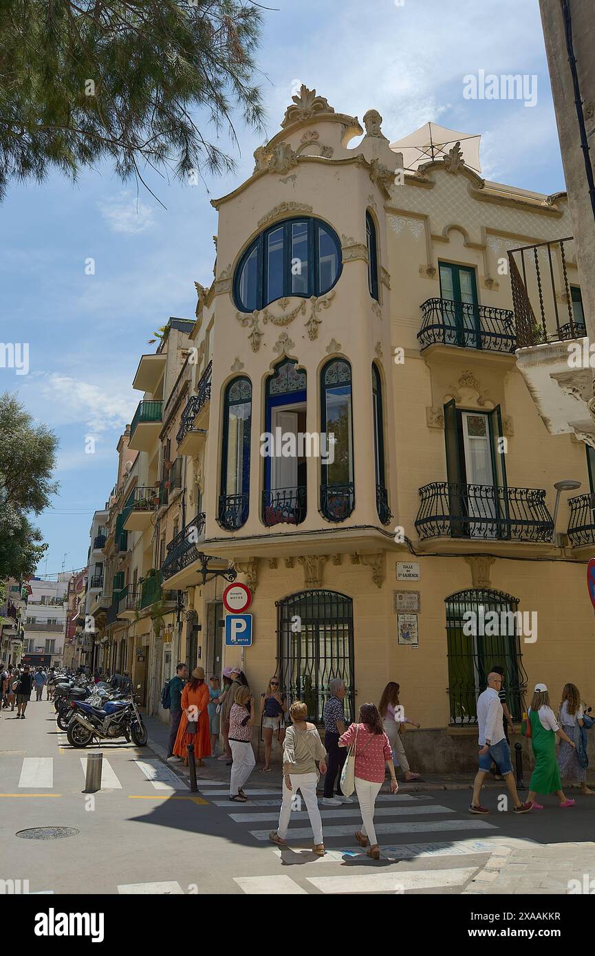 Sitges, Barcelona, Spanien-05. Juni 2024: Das Haus Manel Planas in Sitges zeigt an einem sonnigen Tag mit Menschen seine modernistische Fassade und sein großes ovales Fenster Stockfoto