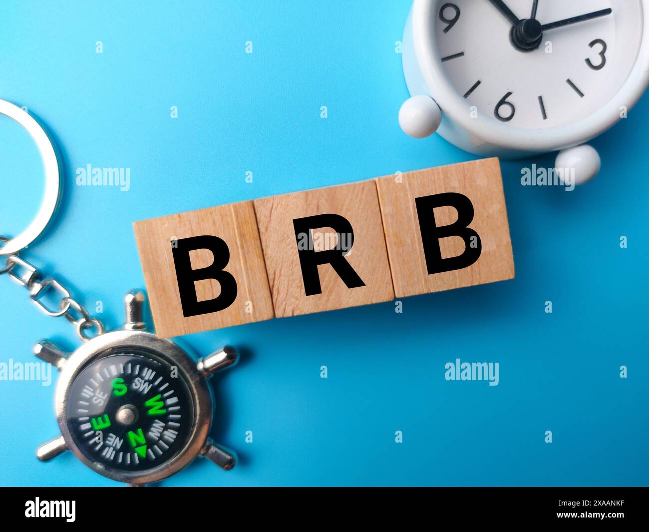 Holzblock mit Draufsicht und dem Wort BRB Be gleich wieder auf blauem Hintergrund. Stockfoto