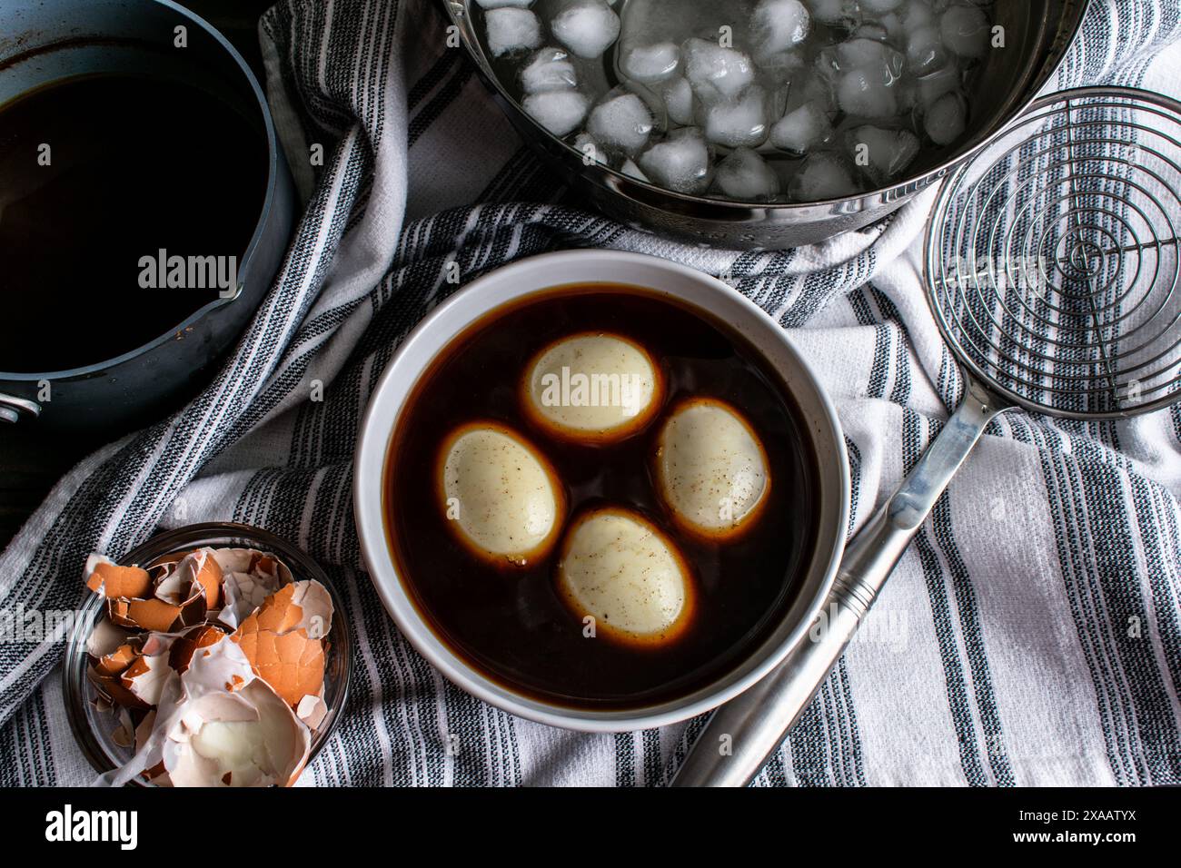 Weich gekochte Eier in Sojasauce-Marinade: Herstellung von Ramen-Eiern durch Marinieren gekochter Eier in gewürzter Sojasauce-Mischung Stockfoto