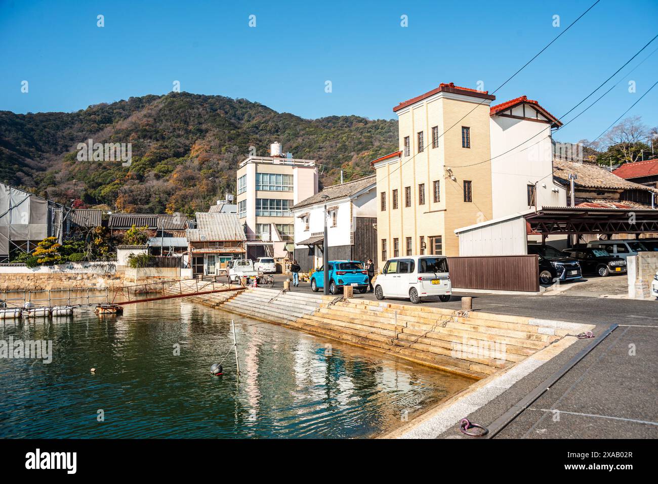 Gebäude an der Uferpromenade von Tomonoura, mit einem türkisfarbenen Wasserbecken davor, Tomonoura, Honshu, Japan, Asien Stockfoto