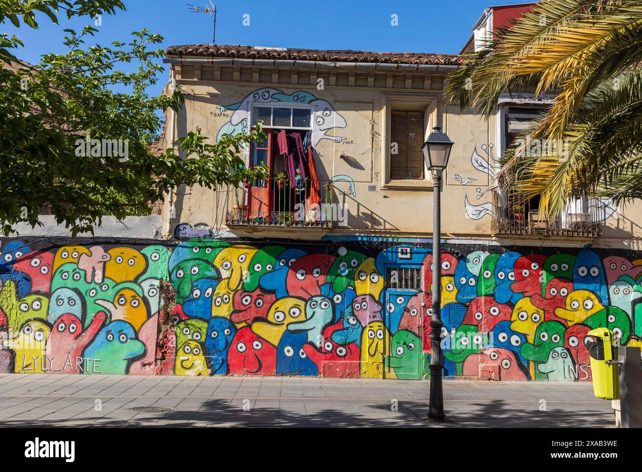 Valencia, Spanien - 20. April 2024. Graffiti in der Cabanyal Gegend, die als benachteiligt gilt. Das Haus hat einen Balkon zum Öffnen. Stockfoto