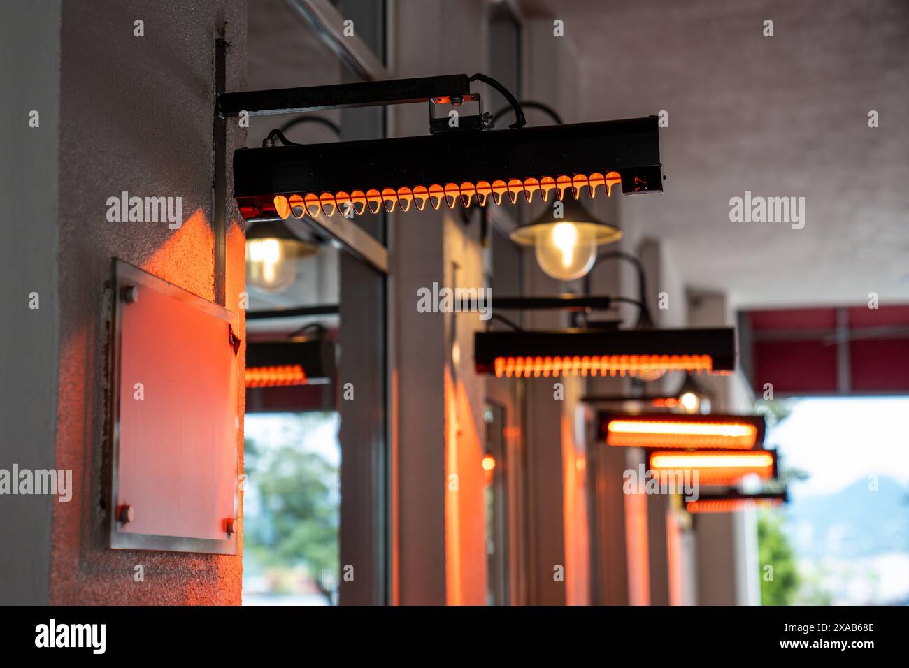 Café mit elektrischen Heizgeräten im Freien für Wärme und Komfort der Gäste, die im Freien speisen. Stockfoto