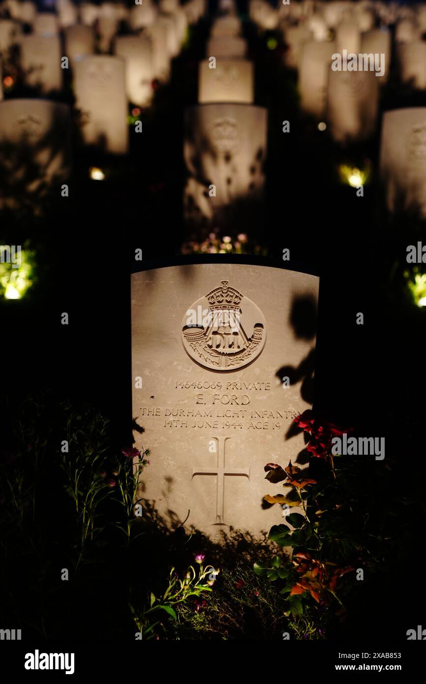 Der Grabstein von E Ford der Durham Light Infantry, der am 14. Juni 1944 im Alter von 19 Jahren starb, wird während der Großen Mahnwache der Commonwealth war Graves Commission anlässlich des 80. Jahrestages des D-Day auf dem Bayeux war Cemetery in der Normandie beleuchtet. Auf dem Friedhof werden 4.600 Gräber von Soldaten des Zweiten Weltkriegs beleuchtet, bevor britische und internationale Mitarbeiter am Stein der Erinnerung eine Mahnwache halten, während die Namen der Gefallenen vorgelesen werden. Bilddatum: Mittwoch, 5. Juni 2024. Stockfoto