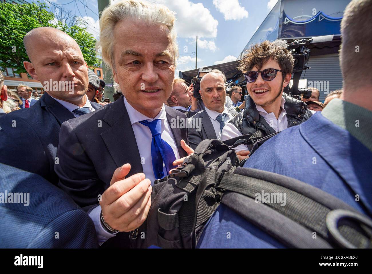 Der niederländische rechtsextreme Politiker Gert Welders, umgeben von seinen Leibwächtern, grüßt einen wohlwollenden, während einer Pressechance des Haagse Marktes. Eine Pressepresse und ein öffentlicher Rausch, als Gert Welders einen Tag vor den Europawahlen eine Pressechance des Haagse Marktes in den Haag hielt. Er gab Presseinterviews und zahlreiche Selfies mit Mitgliedern der Öffentlichkeit. Gert Wilders ist ein Politiker, der die rechtsextreme niederländische Partei (PVV) anführte und 2006 von ihm gegründet wurde. Gegen den Islam war Wilders bei den Wahlen im letzten Jahr an der Spitze der Umfragen und schloss ein Abkommen mit drei anderen Parteiführern. Er rannte Stockfoto
