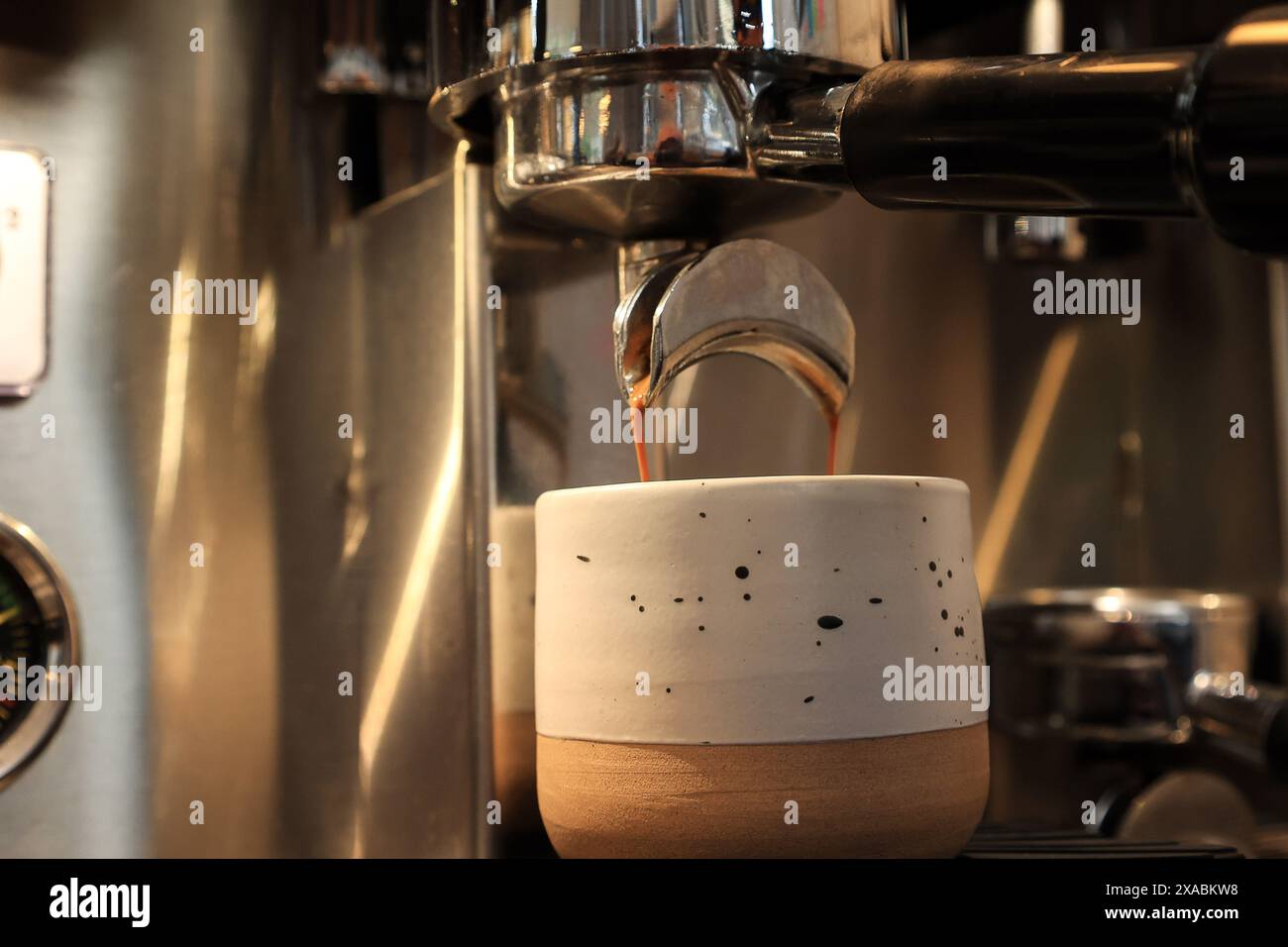 Espresso-Kaffeeauszug aus einer professionellen Kaffeemaschine, Nahaufnahme eines Kaffeetropfens aus der Kaffeemaschine Stockfoto