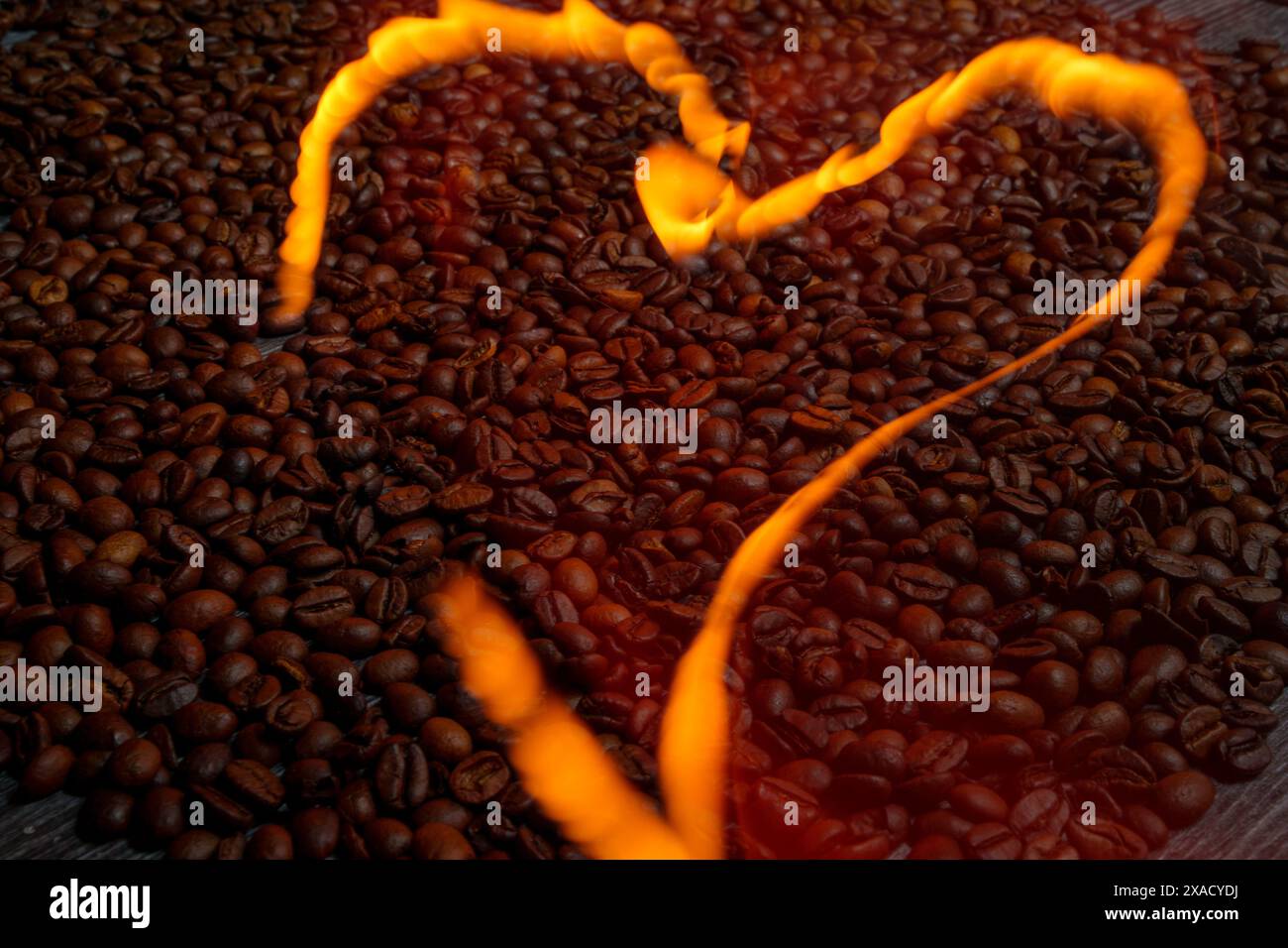 Feuriges Herz über Kaffeebohnen. Hochwertige Fotos Stockfoto