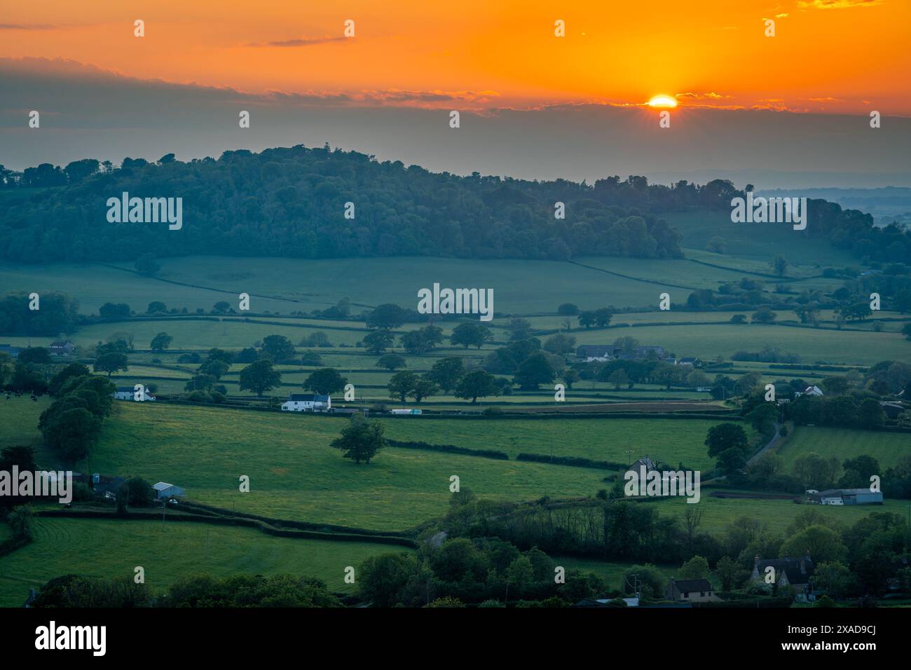 Wunderschöner Sonnenuntergang auf der englischen Landschaft in der Nähe von Batcombe in Dorset County, untergehende Sonne und dramatische Wolken über den Hügeln und Ackerland Stockfoto