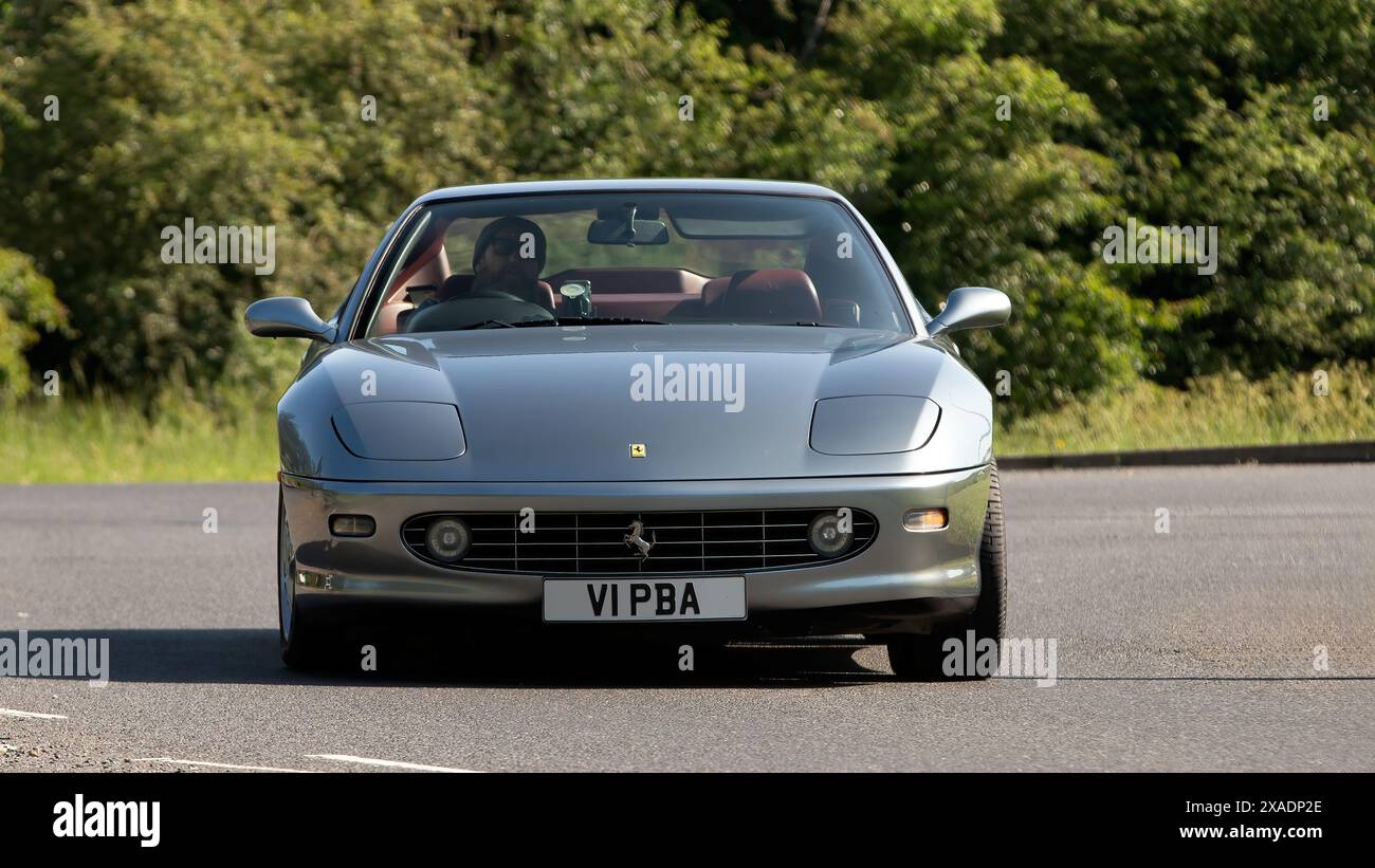 Stony Stratford, UK - 2. Juni 2024: 2000 silberne Ferrari 456 Auto fährt auf einer britischen Landstraße Stockfoto