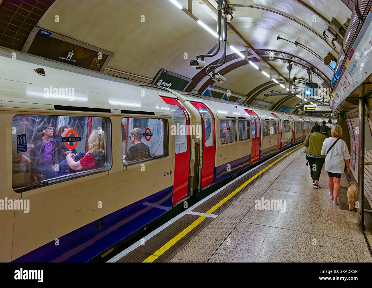 London U-Bahn-typische Zugwagen und Passagiere an einem Bahnhof Stockfoto