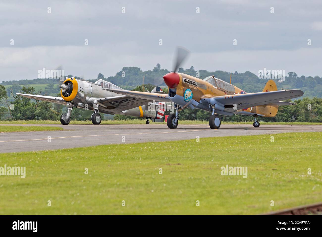 Curtiss P-36C Hawk und Curtiss P-40F Warhawk fahren während der Duxford Summer Air Show: D-Day 80 auf der IWM Duxford vor ihrem Display Stockfoto