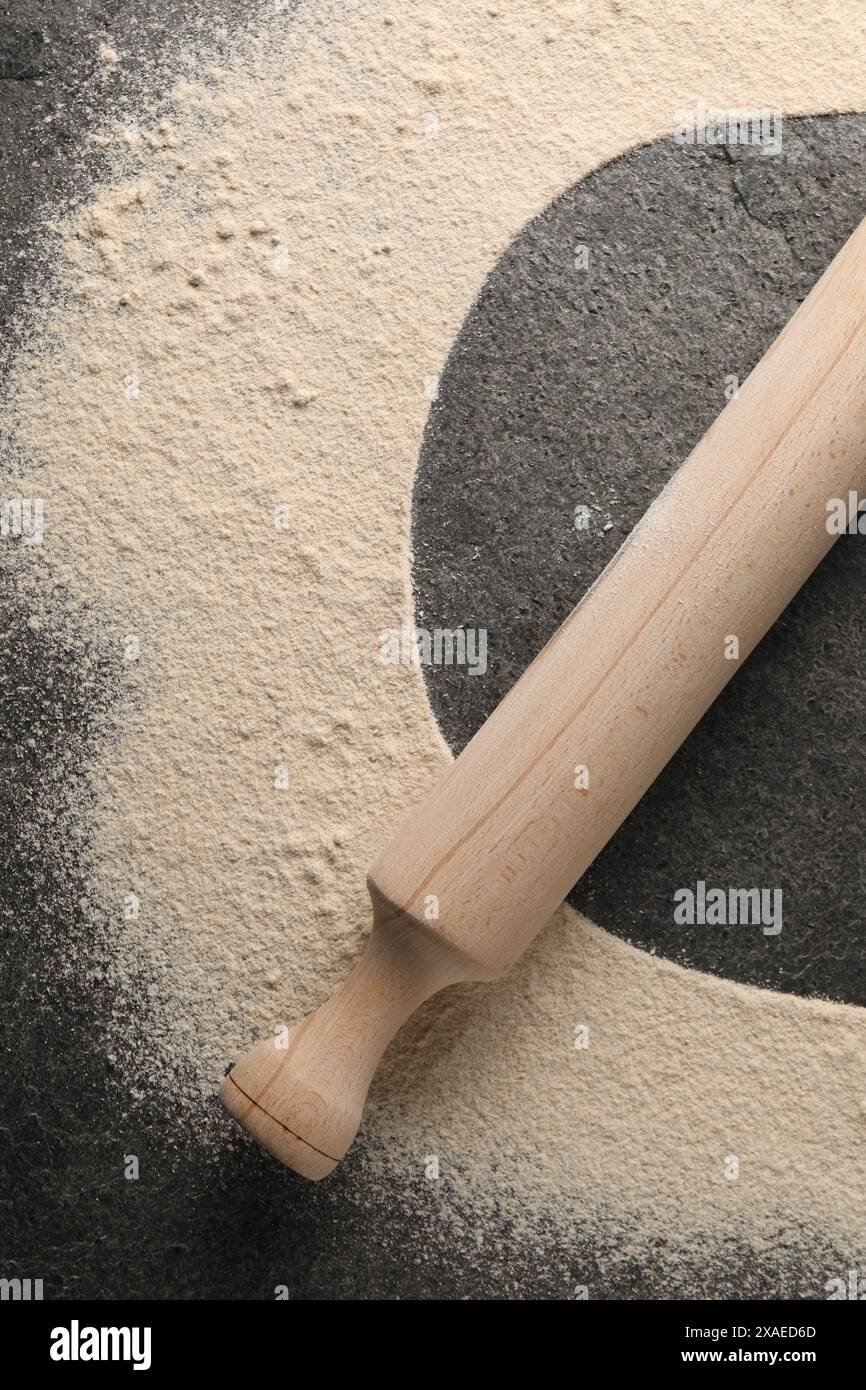 Aufdruck der Platte auf grauem, strukturiertem Tisch mit Mehl und Rollstift, Draufsicht Stockfoto