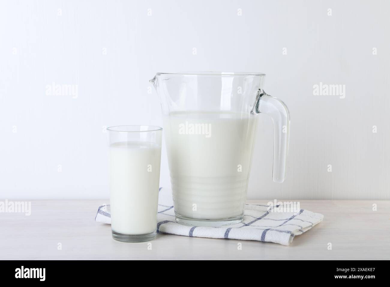 Kanne und Glas frische Milch auf Holztisch Stockfoto