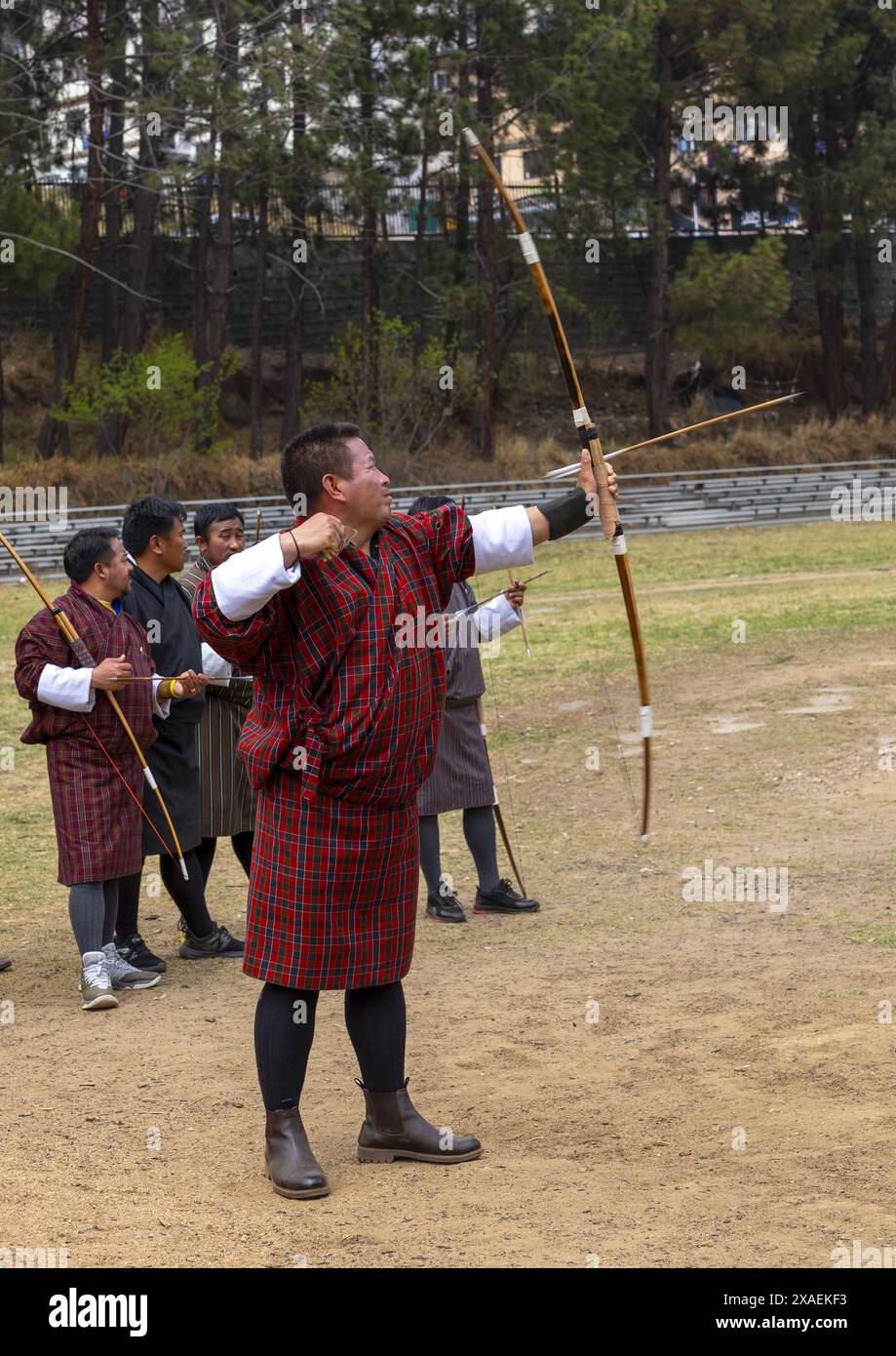 Der bhutanische Mann zielt auf Pfeil im Bogenschießen, Chang Gewog, Thimphu, Bhutan Stockfoto