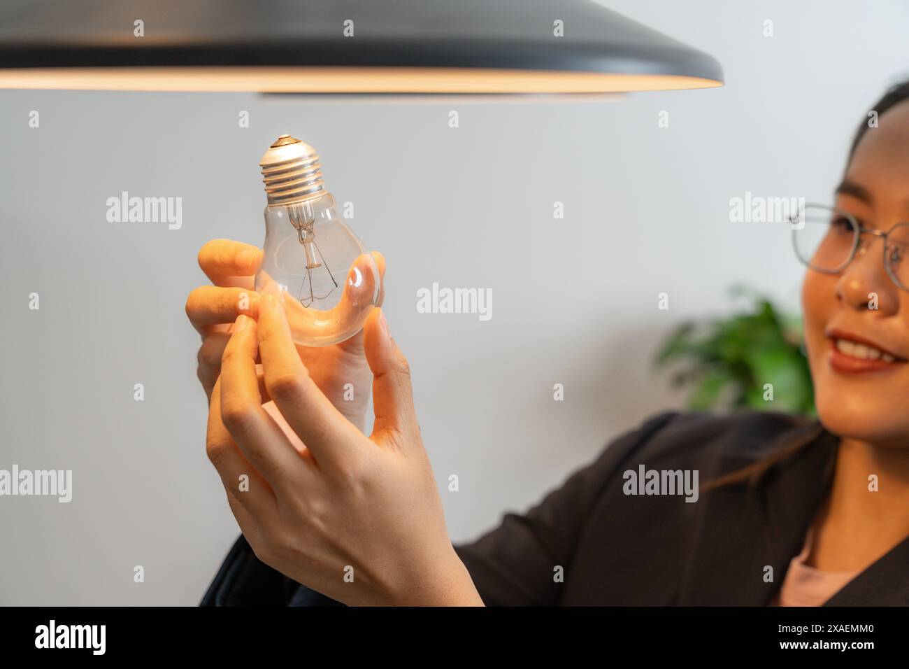 Die junge Frau wechselt zu Hause Glühbirnen Stockfoto