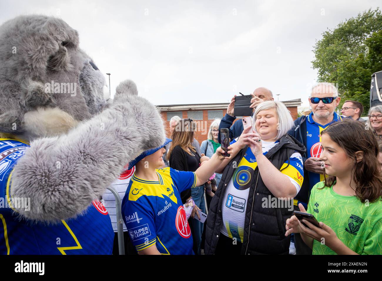 Warrington, Cheshire, Großbritannien. Juni 2024. Warrington Wolves verließ das Halliwell Jones Stadium am 6. Juni 2024 und zog in Richtung Wembley Stadium, um das Finale des Rugby Football League Challenge Cup gegen Wigan zu erreichen. Die Unterstützer waren da, um sie abzuhauen. Wolfie, das Maskottchen, begrüßte die Unterstützer Credit: John Hopkins/Alamy Live News Stockfoto