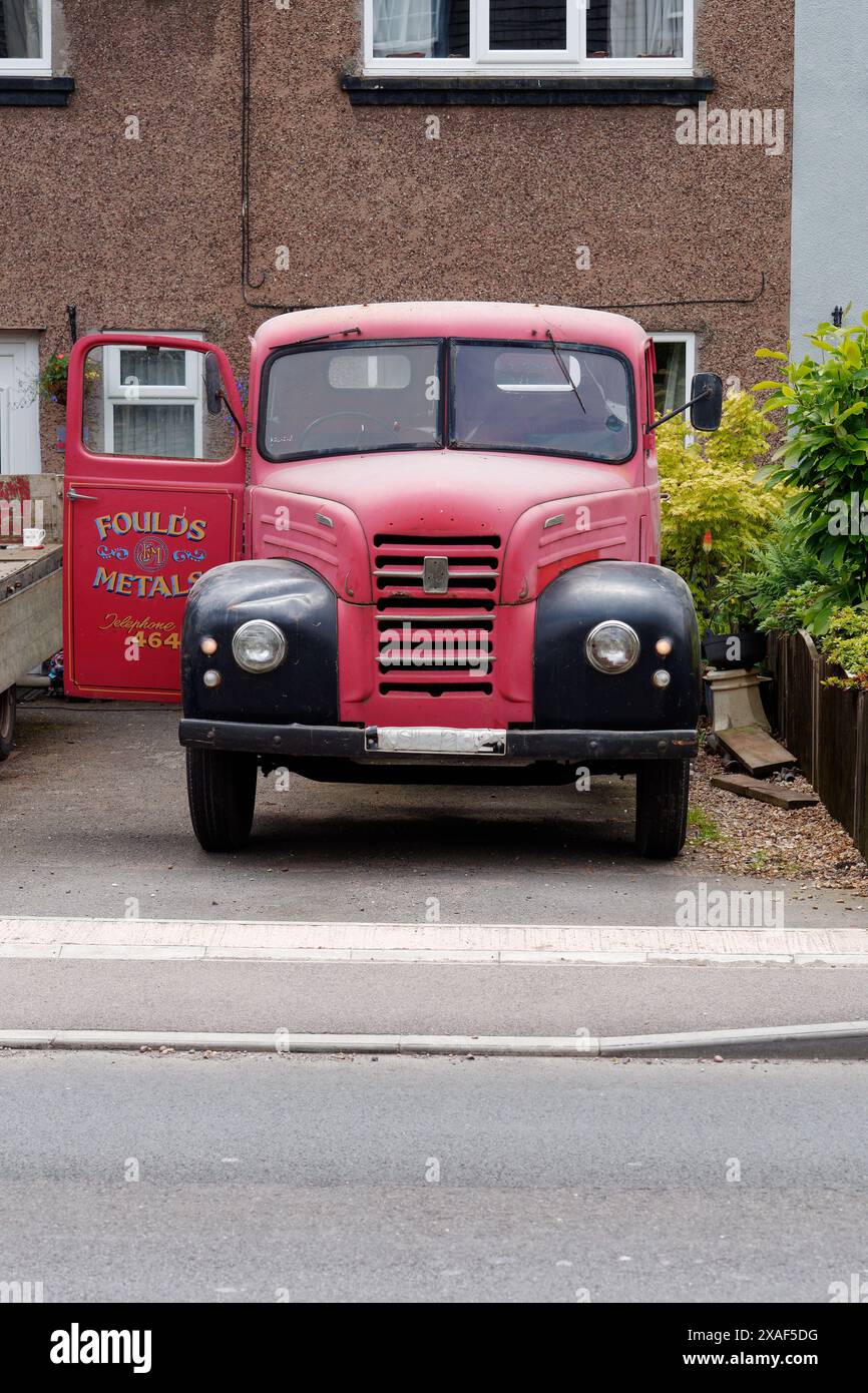 Klassischer roter und schwarzer Pickup-Truck mit Foulds Metal auf der Tür in einer Einfahrt eines Hauses Stockfoto