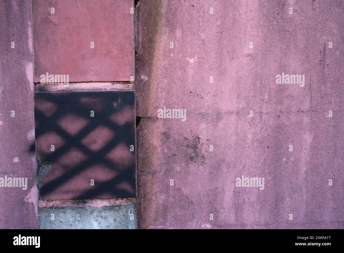 Wand mit alter und schmutziger rosa Farbe mit Rissen für Hintergrund und Inspiration Stockfoto