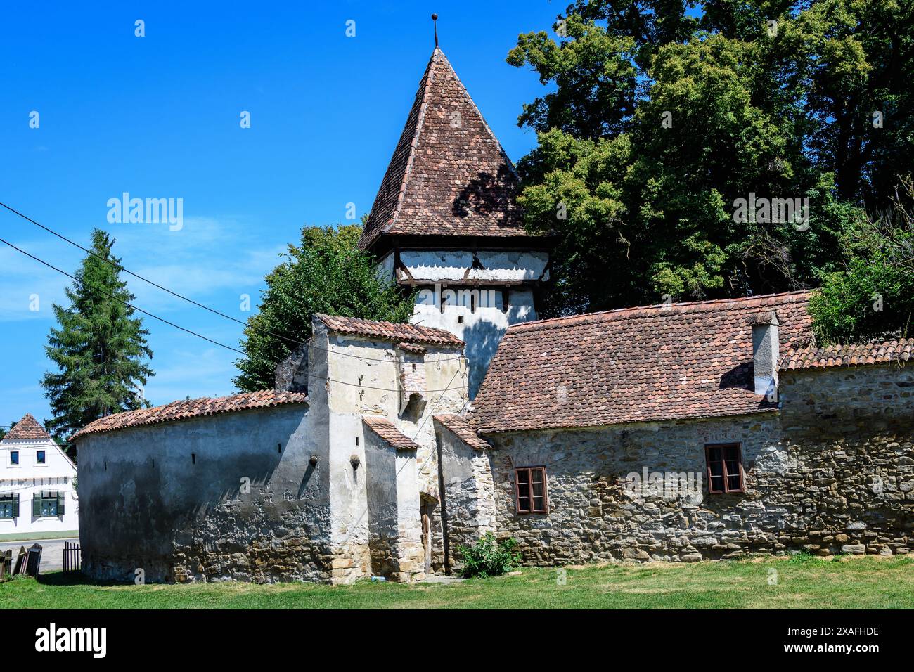 Alter Steinturm an der befestigten Kirche der Heiligen Peter und Paul (Biserica Sfintii Apostoli Petru și Pavel) im Dorf Cincosr, in der Nähe von Fagaras in Siebenbürgen Stockfoto