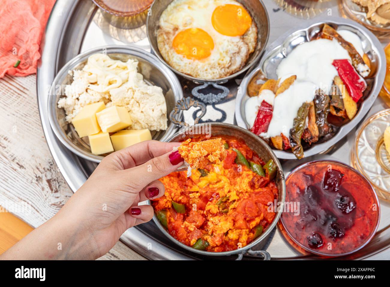 Traditioneller Türkischer Frühstückstisch (Serpme Kahvalti). Traditionelles türkisches Dorffrühstück mit Spiegeleiern in einer Kupferpfanne, Menemen, geklecktem Honig Stockfoto