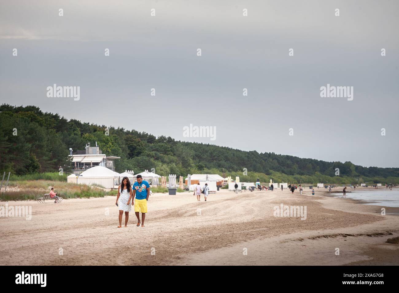 Bild von einem Mann und einer Frau, Liebenden, Paaren, die auf dem Sand in Jurmala laufen, am Strand. Segway ist eine eingetragene Marke von Segway Inc Dean Kam Stockfoto