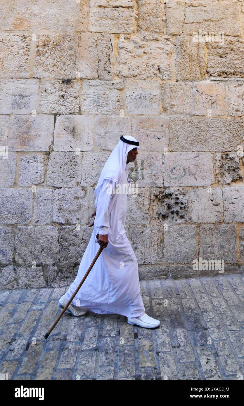 Ein traditionell gekleideter arabischer Mann, der durch das muslimische Viertel in der Altstadt von Jerusalem spaziert. Stockfoto
