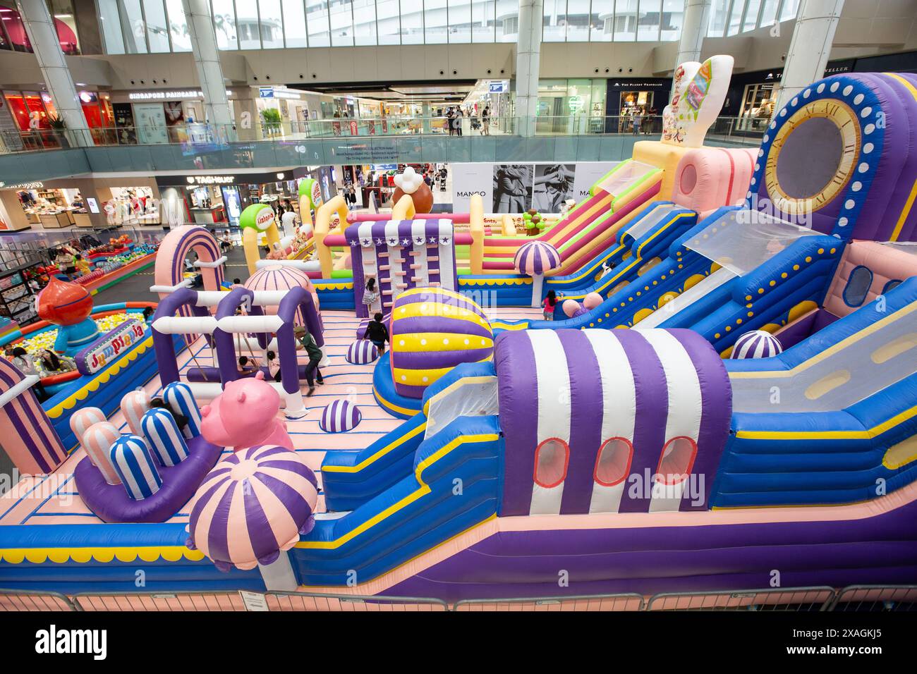 Im Inneren eines geräumigen Einkaufszentrums. Ein riesiges Hüpfschloss ist für Kinder eingerichtet, um unter Aufsicht eines Erwachsenen zu spielen oder ihre Energie zu entfalten. Singapur. Stockfoto