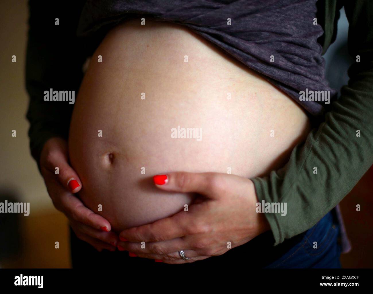 Aktenfoto vom 05/18 einer schwangeren Frau, die ihren Magen hält. Untersuchungen zeigen, dass schwangere Frauen, die auf Intensivmedizin zugelassen werden, erheblichen Risiken für ihr eigenes Leben ausgesetzt sind und dass die Rate der Totgeburten 12-mal höher ist. Forscher der University of Edinburgh nutzten Gesundheitsdatenbanken für mehr als 760.000 Geburten in schottischen Krankenhäusern zwischen 2005 und 2018 und untersuchten alle Schwangerschaften, die zu einer Lebendgeburt, Totgeburt oder späten Fehlgeburten führten. Ausgabedatum: Freitag, 7. Juni 2024. Stockfoto