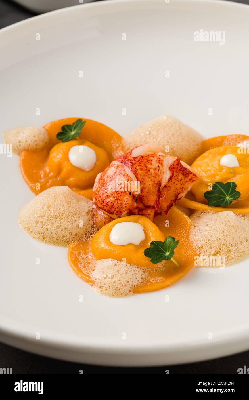 Ravioli mit gegrillten Garnelen auf einem weißen Porzellanteller Stockfoto