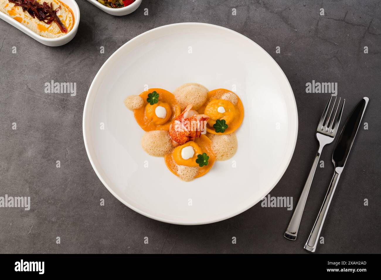 Ravioli mit gegrillten Garnelen auf einem weißen Porzellanteller Stockfoto