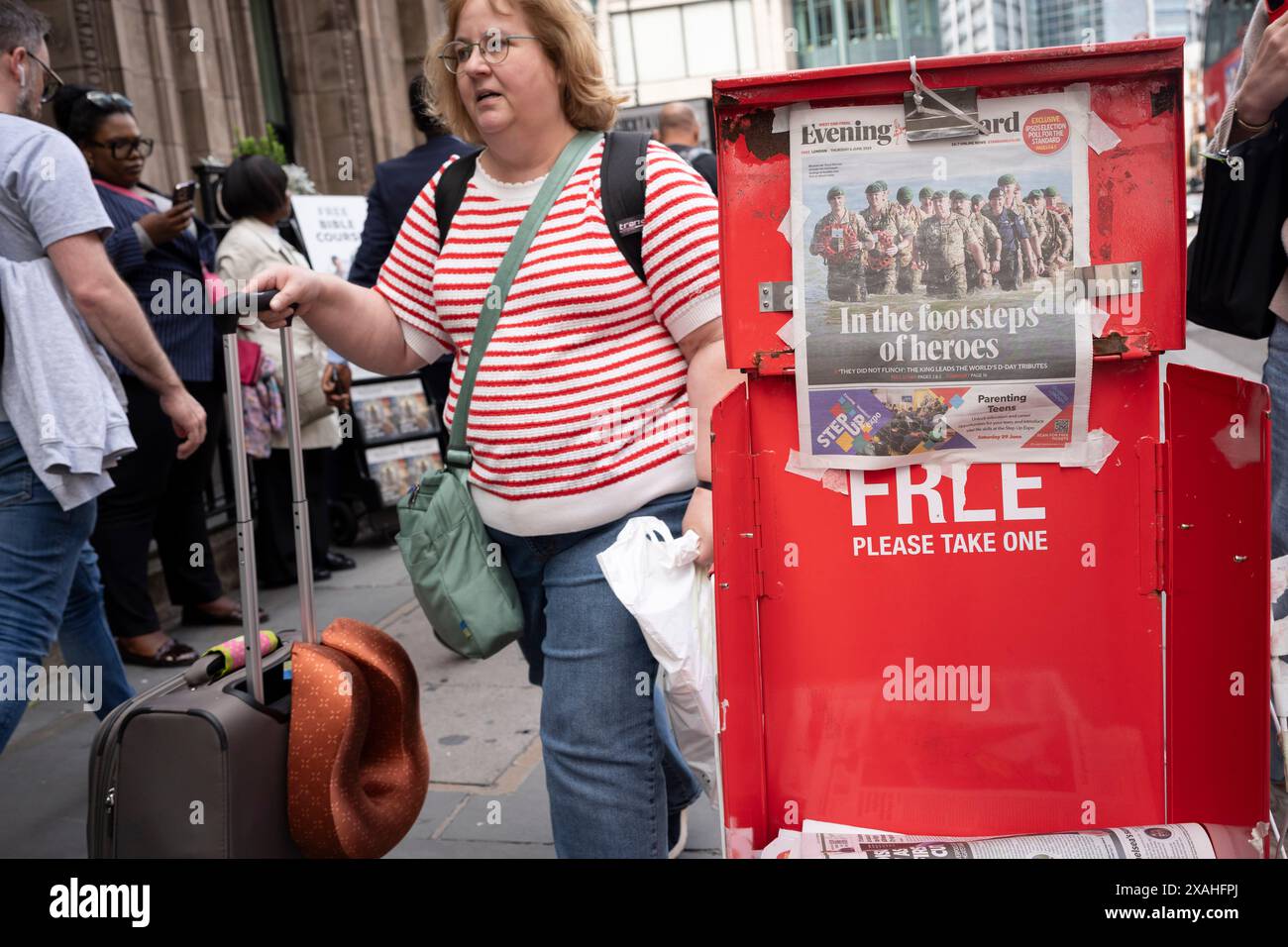 Mitglieder der Öffentlichkeit gehen vorbei an der Evening Standard-Schlagzeile, die den 80. Jahrestag der Landung am D-Day am 6. Juni 2024 in der Liverpool Street Station in der City of London, dem Finanzviertel der Hauptstadt, in London, berichtet. Besitzer des Evening Standard haben angekündigt, dass der Titel der Daily London bald nach 97 Jahren nicht mehr täglich veröffentlicht wird. Stockfoto