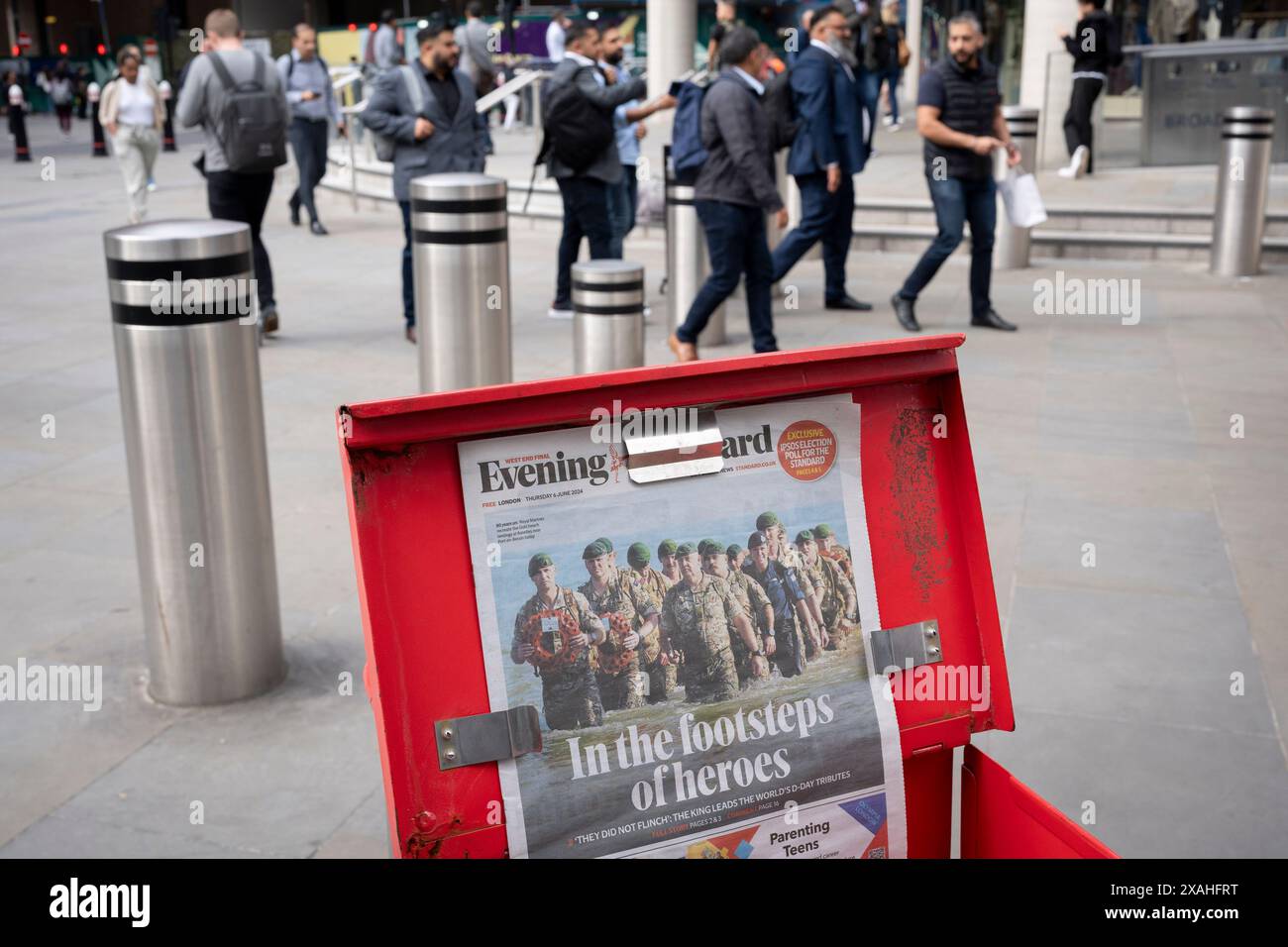 Mitglieder der Öffentlichkeit gehen vorbei an der Evening Standard-Schlagzeile, die den 80. Jahrestag der Landung am D-Day am 6. Juni 2024 in der Liverpool Street Station in der City of London, dem Finanzviertel der Hauptstadt, in London, berichtet. Besitzer des Evening Standard haben angekündigt, dass der Titel der Daily London bald nach 97 Jahren nicht mehr täglich veröffentlicht wird. Stockfoto