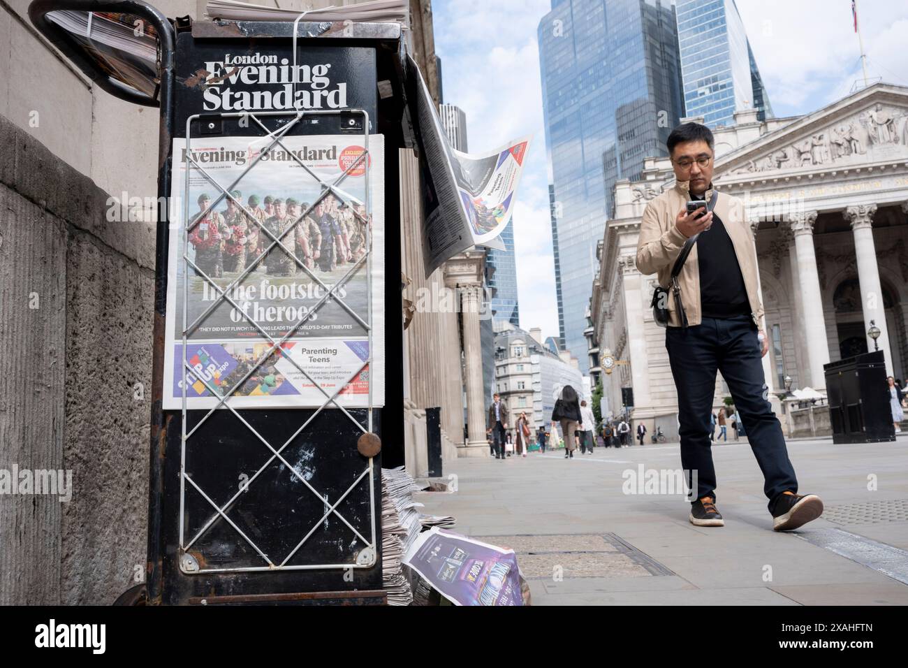 Mitglieder der Public Walk Past the Evening Standard News Schlagzeile, die über den 80. Jahrestag der Landung des D-Day in der City of London, dem Finanzviertel der Hauptstadt, am 6. Juni 2024 in London, England berichtet. Besitzer des Evening Standard haben angekündigt, dass der Titel der Daily London bald nach 97 Jahren nicht mehr täglich veröffentlicht wird. Stockfoto