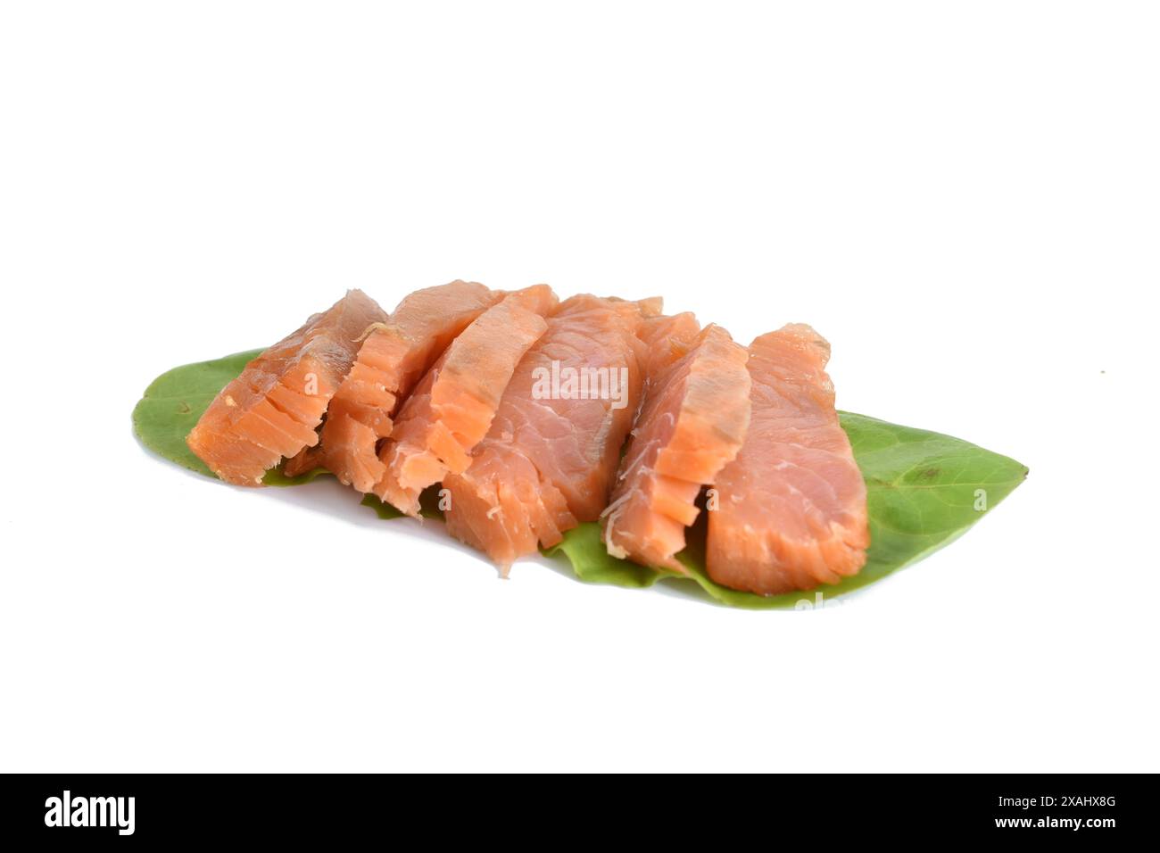 Das Bild zeigt Lachsstücke, die auf Salatblättern liegen. Stockfoto