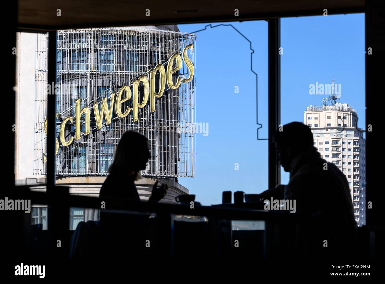 Das Schweppes-Werbeschild auf dem Carrion-Gebäude aus Sicht eines Cafés in der Gastronomie des Einkaufszentrums El Corte Ingles auf der Plaza de Callao, Stockfoto