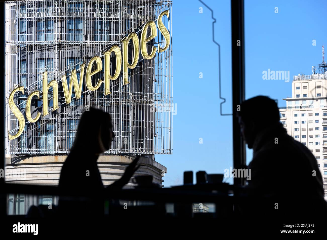 Das Schweppes-Werbeschild auf dem Carrion-Gebäude aus Sicht eines Cafés in der Gastronomie des Einkaufszentrums El Corte Ingles auf der Plaza de Callao, Stockfoto