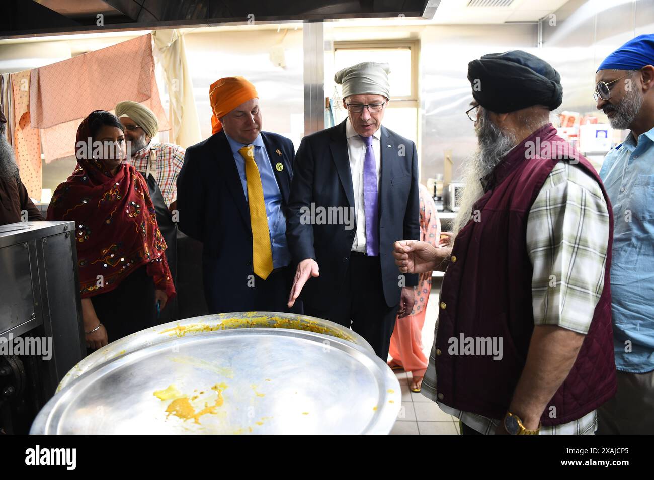 SNP-Chef John Swinney und Parlamentskandidat Chris Stephens werden die Küchen während seines Besuchs in Glasgow Gurdwara gezeigt, während er sich auf dem Wahlkampfpfad der Wahl befindet. Bilddatum: Freitag, 7. Juni 2024. Stockfoto